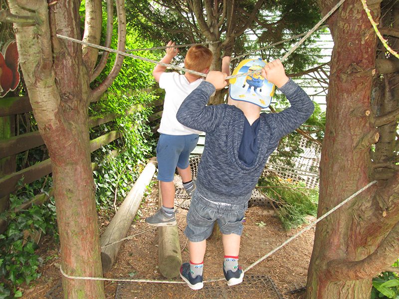 Two children balancing on the rope walk in our forest area
